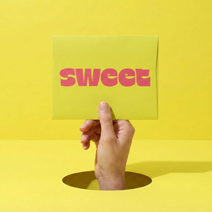 A SWEET Love Letter — a hand rising through a hole in a yellow floor holding up a card reading sweet