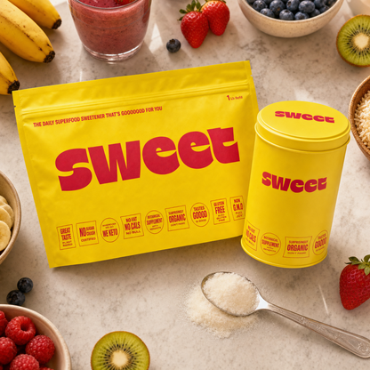 Overhead view of a SWEET refill pouch and tin on a counter with bananas, berries, kiwi and a smoothie