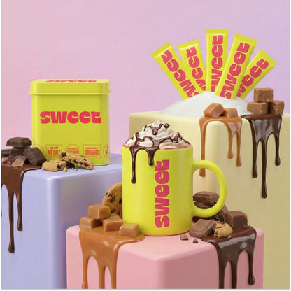 THE SWEETUAL™ — tin and a whipped-cream mug with chocolate drizzle, fanned stick packets, cookies, and caramel nearby
